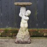 A reconstituted stone figural birdbath,