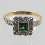 An 18 carat gold and platinum set emerald and diamond cluster ring,