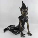 A bronze figure of a seated pixie,