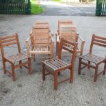 A set of four teak slatted garden armchairs,