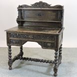 A 19th century heavily carved dark oak green man writing desk, on spirally turned legs,