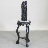 An oriental hardwood jardiniere stand, inset with a blue and white pottery tray, 66cm high,