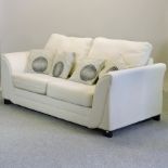 A modern cream upholstered sofa,