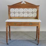 An Edwardian satin walnut marble top washstand, with a tile back,