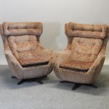 A pair of 1970's pink upholstered swivel lounge chairs