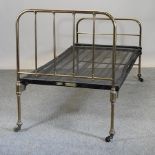An early 20th century brass single bedstead, with metal base, bearing a label for Shoolbred,