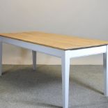 An oak kitchen table, on white painted square legs,