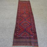 A Turkish woollen runner, with four central medallions on a red ground,