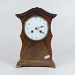 An Edwardian mantel clock with an enamel dial,