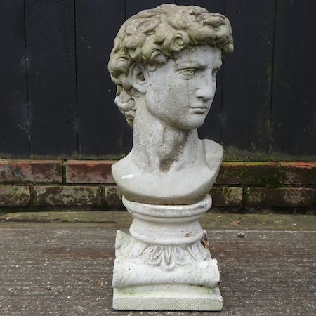 A reconstituted stone bust of a man, on a similar plinth,