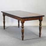 A stained pine dining table on turned legs,