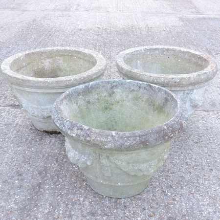 A set of three reconstituted stone garden planters,