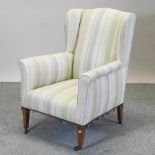 An Edwardian cream upholstered wing back armchair