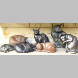 A collection of bronzed and wooden models of cats,