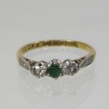 An 18 carat gold emerald and diamond three stone ring