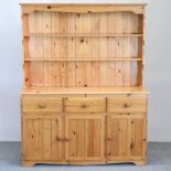 A pine dresser, with cupboards below,