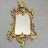 A gilt painted wall mirror, surmounted by a bird,