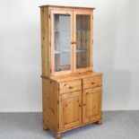 A modern pine cabinet bookcase, with glass shelves,