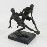 A bronze model of two footballers, on a black veined marble base,