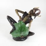 A bronze figure of a pixie, holding a lily pad,