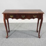 A cherrywood three drawer side table,