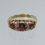 An 18 carat gold ruby and diamond three stone ring,