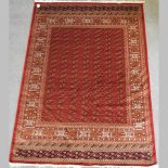 A Bokhara style carpet on a red ground,