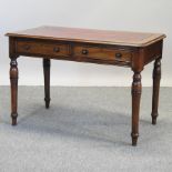 A Victorian walnut writing table, on turned legs,