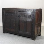 An 18th century carved oak side cabinet,