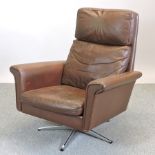 A 1970's brown upholstered swivel armchair,