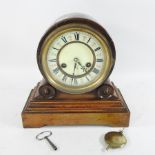 An Edwardian walnut mantle clock, with a white enamel dial,