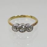 An 18 carat gold and collet set diamond three stone ring