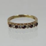 A 9 carat gold ruby and diamond half hoop eternity ring