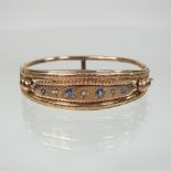 A 9 carat rose gold and gem set bangle, of hinged design, 6.