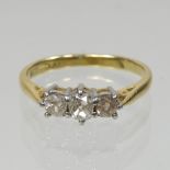 An 18 carat gold and diamond three stone ring,