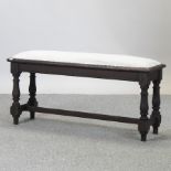 A cream upholstered long footstool,