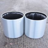 A pair of silver painted circular garden pots,