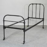 A green painted iron single bedstead,