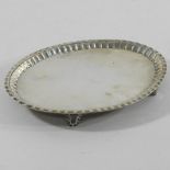 A George III silver waiter, of oval shape with a crimped border, on four scrolled feet, London 1787,