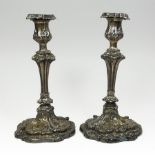 A pair of George III silver table candlesticks, each with relief scrolled decoration,