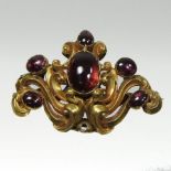 A yellow metal brooch, of scrolled design, set with six cabochon stones, unmarked,