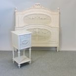 A cream painted pine double bedstead, 142cm, together with a bedside cabinet,