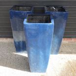 A set of three large blue garden pots,