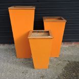 Three graduated orange garden pots,