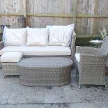 A rattan three seater garden sofa, 183cm, together with a coffee table,