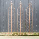 A folding metal garden lattice spire, together with two others,