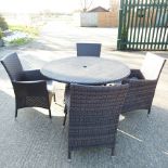 A brown rattan circular garden table, 120cm diameter,