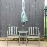 A green painted metal garden seat, together with a parasol,