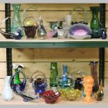 Two shelves of coloured glass to include vases and baskets