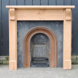 A cast iron fire insert, with a pine surround,